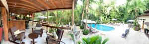 an outdoor patio with a pool and tables and chairs at The Falls by Lalibela in Manuel Antonio