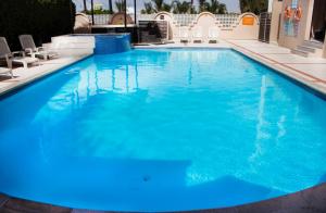 a large swimming pool with blue water at Del Mar Inn Rosarito in Rosarito