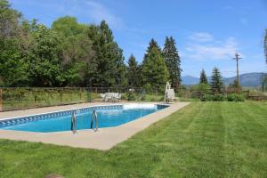 ein Swimmingpool in einem Garten neben einem Rasenfeld in der Unterkunft Northside School Bed & Breakfast in Bonners Ferry
