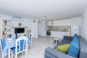 ein Wohnzimmer und eine Küche mit einem Sofa und einem Tisch in der Unterkunft Apartment Island Dream in Krapanj