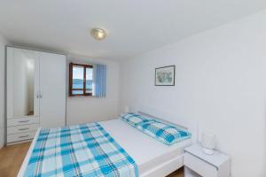 ein weißes Schlafzimmer mit einem Bett und einem Spiegel in der Unterkunft Apartment Island Dream in Krapanj