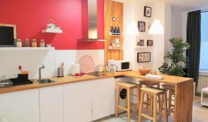 una cocina con armarios blancos y una pared roja en La Casa de Cayetana AT-47-44, en Valladolid