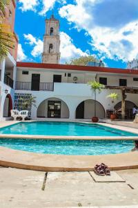 a swimming pool in a building with a clock tower at Hotel San Clemente in Valladolid