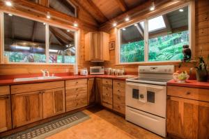 a kitchen with wooden cabinets and a white stove top oven at Volcano Mist Cottage in Volcano