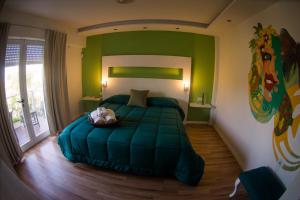 a bedroom with a green bed with a dog laying on it at Punta Encanto Posada Boutique in Miramar