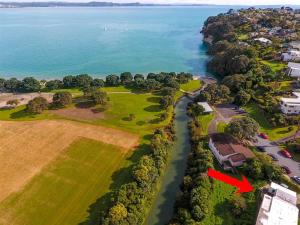 an aerial view of a home with a red arrow at Stanmore Bay Beach House in Whangaparaoa
