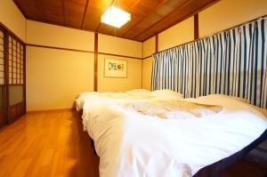 a room with two beds in a room at Rainbow Takayama Private House in Takayama