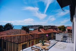 a balcony with a table and chairs on a roof at SU Hotel in Ohrid