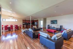 a living room with couches and chairs and a kitchen at 141 Providence Drive, Bowhill in Bow Hill