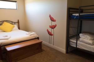 - une chambre avec 2 lits superposés et des fleurs rouges sur le mur dans l'établissement 141 Providence Drive, Bowhill, à Bow Hill