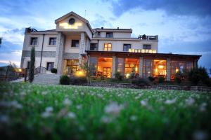 a large white house with a lot of windows at Hotel Aria in Podgorica