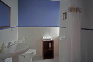 a bathroom with a white toilet and a sink at La Rectoral de San Juan in El Franco