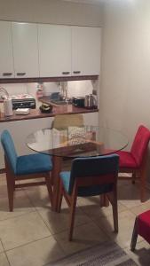 eine Küche mit einem Glastisch und Stühlen in der Unterkunft Vista al mar sector Cochoa- Primera línea in Viña del Mar