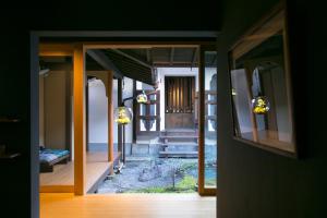 an open door of a house with a view of a garden at Ryokan Mugen (Adult Only) in Kyoto