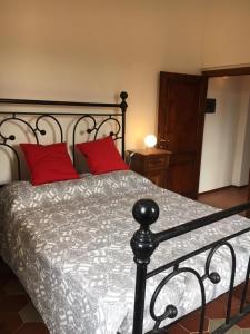 a bedroom with a bed with two red pillows at Villino Chianti in Cavriglia