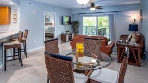 uma sala de estar com uma mesa de vidro e cadeiras em Honu Hideaway at Ocean Walk Resort em New Smyrna Beach