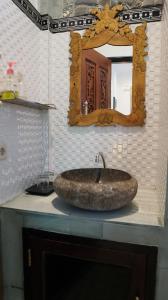 a sink in a bathroom with a mirror and a counter at Hotel Suma in Lovina