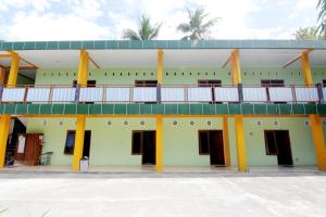 a building with doors and a balcony on top at Losmen Alden in Yogyakarta