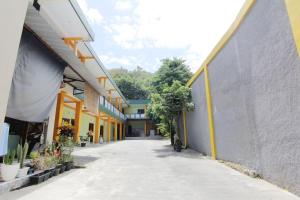 an empty hallway of a building with yellow and gray walls at Losmen Alden in Yogyakarta