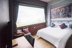 um quarto com uma cama e uma grande janela em Lancasa Taitung em Taitung City