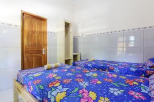 ジョグジャカルタにあるLosmen Aldenのベッドルーム1室(ベッド2台付)、木製のドアが備わります。