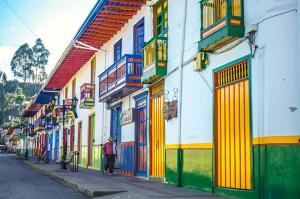 a person walking down a street with colorful buildings at Casa Maral Hostal in Salento