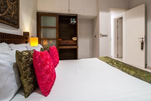 a bedroom with a white bed with red pillows at Samui Sunset 22G in Choeng Mon Beach +88 photos