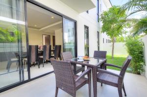 a dining room with a table and chairs on a patio at 4BDR Pool Villa In Laguna Park #40 in Bang Tao Beach