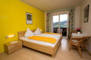 a bedroom with a bed and a table and a window at Landhaus Gastein in Seeboden