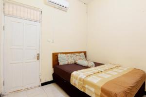 una piccola camera con un letto e una porta bianca di JJ House Gejayan a Yogyakarta Altre 31 foto