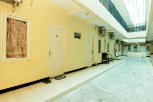 un corridoio vuoto in un vecchio edificio con finestra di JJ House Gejayan a Yogyakarta