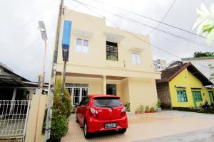 a red car parked in front of a house at JJ House Gejayan in Yogyakarta