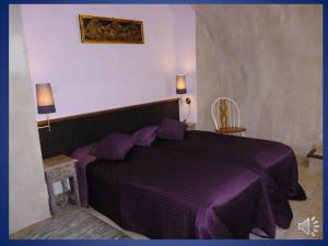 1 dormitorio con 1 cama de color púrpura y 2 lámparas en Domaine de La Tour, en Salavas