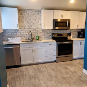 a kitchen with white cabinets and stainless steel appliances at Baby Blue Sky - Price 2bd - Newly remodeled - nearby trails in Price