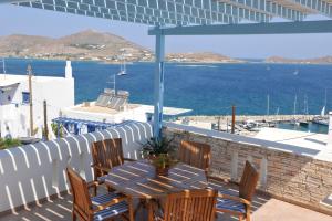 a patio with a table and chairs and the ocean at Katerina Apartments & Studios in Naousa