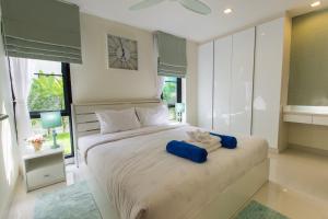 um quarto com uma cama com duas toalhas azuis em 4 bdr villa with cinema in Laguna, 800 m to beach #157 em Praia de Bang Tao