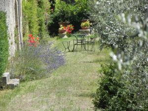 een tuin met een tafel, stoelen en bloemen bij Castello di Grotti in Corsano