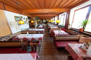 un ristorante vuoto con tavoli, sedie e finestre di Gasthof Koglerhof a Ternberg Altre 19 foto