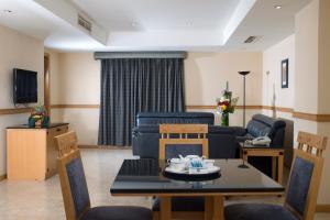 salon ze stołem, krzesłami i kanapą w obiekcie Baisan International Hotel w mieście Manama
