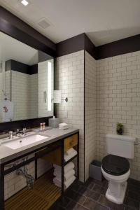 a bathroom with a toilet, sink, and mirror at Hotel 50 Bowery, part of JdV by Hyatt in New York