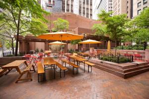 an outdoor patio with tables and chairs and umbrellas at Hyatt Centric Wall Street New York in New York