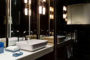a bathroom with two sinks and two mirrors at Hyatt Centric Wall Street New York in New York