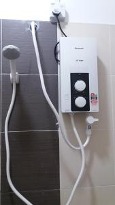 un cordon blanc fixé à un mur dans une salle de bain dans l'établissement Kasa Heights Homestay, à Malacca