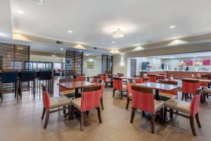 a restaurant with tables and chairs and a bar at Comfort Suites Lafayette University Area in Lafayette