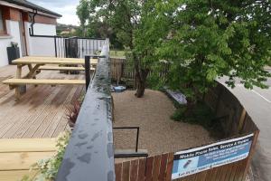 a garden with a fence and a bench on a deck at 9 Sheraton Apartments in Fort William