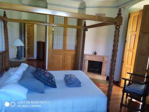 a bedroom with a canopy bed with a fireplace at Palacete Peñanora in Oviedo