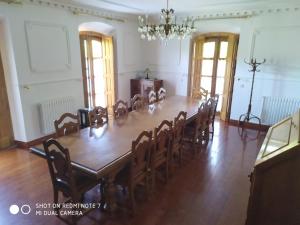 uma grande sala de jantar com uma grande mesa e cadeiras em Palacete Peñanora em Oviedo