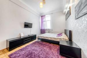 sypialnia z łóżkiem z fioletowym dywanem w obiekcie Apartment on Karl Marx Street w Mińsku