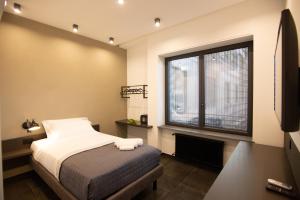 a bedroom with a bed and a large window at napoliurbansuite in Naples