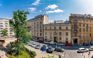 ワルシャワにあるMokotowska 67 Prywatne mieszkanie z balkonem w Centrum miasta i w pobliżu Ambasady USAの車が建物の前に停まった街道